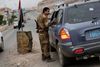 En yemenitisk soldat inspicerer en bil ved et checkpoint tæt på den amerikanske ambassade i Yemens hovedstad, Sanaa.