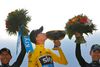 Chris Froome kysser Tour-trofæet, mens han står på podiet. Til venstre nummer to, Colombias Nairo Quintana, til højre Alejandro Valverde, Spanien, der blev nummer tre. Foto: Christophe Ena/AP