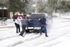 CORRECTION / TOPSHOT - Residents help a pickup driver get out of ice on the road in Round Rock, Texas, on February 17, 2021, after a winter storm. - Millions of people were still without power on Wednesday in Texas, the oil and gas capital of the United States, and facing water shortages as an unusual winter storm pummeled the southeastern part of country. (Photo by Suzanne CORDEIRO / AFP) / "The erroneous mention[s] appearing in the metadata of this photo by Suzanne CORDEIRO has been modified in AFP systems in the following manner: [2021] instead of [2020]. Please immediately remove the erroneous mention[s] from all your online services and delete it (them) from your servers. If you have been authorized by AFP to distribute it (them) to third parties, please ensure that the same actions are carried out by them. Failure to promptly comply with these instructions will entail liability on your part for any continued or post notification usage. Therefore we thank you very much for all your attention and prompt action. We are sorry for the inconvenience this notification may cause and remain at your disposal for any further information you may require."