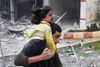 En ung syrer bærer sin søster i sikkerhed i Aleppo. Foto: Abdullah al-Yassin/AP