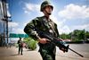 Soldater patruljerer i det område i udkanten af Bangkok, hvor mange af de såkaldte rødskjorter, der støtter regeringen, jævnligt demonstrerer. Foto: AP