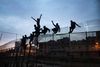 Migranter forsøger at forcere hegnet omkring den spanske enklave Ceuta. Arkivfoto: AP