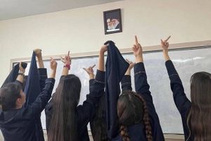 Et billede fra de sociale medier, viser skolerpiger i Iran give fingeren til et billede af landets øverste leder og hans forgænger. Foto: Twitter