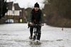 Themsen er over lange strækninger gået over sine bredder, og det har forvandlet gader i omkringliggende landsbyer til vandløb – bl.a. i Staines-upon-Thames. Foto: Lefteris Pitarakis/AP