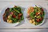 Der er 32 g protein på begge tallerkener, selv om der kun er 14 g bøf på den til højre. Den hele bøf til venstre tegner sig for 27 g protein, mens jeg for at følge EAT-Lancet-kommissionens vejledninger måtte helt op at ramme loftet for både kikærter og edamamebønner og desuden tilføje jordnødder, spinat og broccoli for at nå samme mængde proteiner i den klimavenlige. Her får man til gengæld 195 g mad og 50 kcal. ekstra – og mere end fire gange så mange kostfibre. Foto: Karen Lyager.