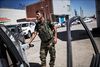 Soldaten Mohamad Ahmad er på vej til fronten, men de 30 liter, han efter tre timers ventetid i køen får lov at købe, rækker ikke så langt.