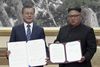 Moon Jae-in (tv.) og Kim Jong Unfremviser de underskrevne dokumenter. Foto: Korea Broadcasting System via AP