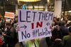 'Lad dem komme ind,' står der på skiltet, som en kvinde holder i lufthavnen i Los Angeles i kølvandet på Trumps beslutning om ikke at lukke folk fra en række muslimske lande ind i USA. Foto: Reed Saxon/AP