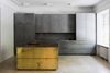 Den svenske designer Richard Lindwalls nye projekt Gold & Gray Apartment er gennemført, gråt, råt og minimalistisk tilført få gyldne messingkontraster, som køkkenøen her. Foto: Mikael Axelsson