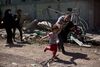 En far skynder på sin datter, da de flygter fra et område i Mosul, imens Islamisk Stat kæmper mod irakiske styrker i den vestlige del af byen onsdag. Foto: Maya Alleruzzo