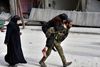 Billedet her er udgivet af den syriske nyhedsstation SANA og viser en syrisk soldat, der bærer en såret kvinde ud af det Østlige Aleppo. Foto: SANA via AP