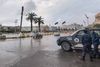 Policemen stand by a stationary patrol vehicle at the Martyrs' Square of Libya's capital Tripoli on December 13, 2021. (Photo by Mahmud Turkia / AFP)