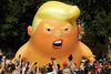 FILE - In this Friday, July 13, 2018 file photo, a six-meter high cartoon baby blimp of U.S. President Donald Trump is flown as a protest against his visit, in Parliament Square in London, England. Trump's long-delayed state visit on June 3, 2019, timed to coincide with ceremonies marking the 75th anniversary of the D-Day invasion, has been deeply divisive since May extended the invitation on behalf of the queen in the first week of Trump's administration. The invitation prompted street protests, an online petition signed by more than 1 million opposed to the idea, and a debate in Parliament over whether Trump deserved the highest honor Britain can bestow on a foreign leader. (AP Photo/Matt Dunham, file)