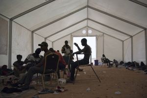 Migranter venter på at få afgjort deres skæbne i en flygtningelejr i Agadez i Niger. Flere tusinde er blevet efterladt i Algeriet af myndighederne, og må så gå med meget lidt mad og drikke gennem Sahara for at komme til lejren for at få hjælp. Foto: Jerome Delay/AP