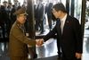 Sydkoreas genforeningsminister og en højtstående nordkoreansk udsending giver hinanden hånden lørdag.