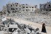 En palæstinenser går forbi murbrokker fra huse, som blev ødelagt af israelske angreb i Beit Hanoun i den nordlige del af Gazastriben.