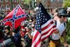 Hvide nationalister og Ku Klux Klan-medlemmer med sydstatsflag maste sig lørdag forbi moddemonstranter, da de troppede op ved en omstridt park i Charlottesville, Virginia. Nu er staten erklæret i nødretstilstand. Fioto: Steve Helber/AP.