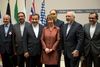 EU’s udenrigschef, Cathrine Ashton, sammen den iranske udenrigsminister, Muhammed Javad Zarif, og den iranske delegation, da den foreløbige aftale var forhandlet i Genève i november. Nu er der enighed om, at den kan blive implimenteret fra den 20. januar. Arkivfoto: Martial trezzini/AP