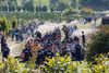Ungarske politibetjente leder en strøm af flygtninge og migranter, der har krydset grænsen fra Kroatien, mod en nærliggende banegård. På grund af den fortsatte tilstrømning af mennesker fik Ungarn særstatus i fordelingsbeslutningen. Foto: Gyorgy Varga/AP