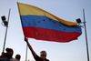 En venezuelansk flygtning, der er flygtet til Chile, løfter det venezuelanske flag i Santiago i en demonstration mod præsident Maduro tirsdag den 30. april. Foto: Ivan Alvarado/Reuters.