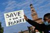 FILE PHOTO: A demonstrator holds up a sign as he attends a Fridays for Future climate strike in Milan, Italy ahead of Glasgow's COP26 meeting. Picture taken on October 1, 2021. REUTERS/Flavio Lo Scalzo/File Photo