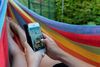 Hyggestund med mobilen i hængekøjen. De 7-12-årige bruger dagligt godt tre timer på skærme, og når de bliver ældre stiger tidsforbruget ved skærmene.
