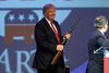 Donald Trump støtter som de øvrige republikanske kandidater retten til at eje våben. Her ses han med en Henry-riffel ved et møde i Hot Springs i Arkansas 17. juli. Foto Danny Johnston/AP.