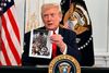 Præsident Donald Trump fremviser i en video natten til fredag et billede fra et af de fly, der fløj folk ud af Afghanistan under USA's tilbagetrækning fra landet i 2021. Trump mener, at de forkerte var om bord på flyene. Foto: Jim Watson/Ritzau Scanpix