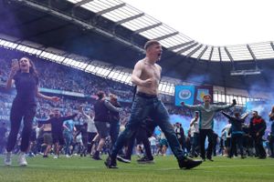 Fans strømmede ind banen, da Manchester City havde sikret sig mesterskabet med en 3-2 sejr over Aston Villa på Etihad Stadium. Undervejs blev Aston Villa-målmand Robin Olsen - med en fortid i FC København - udsat for et angreb. Foto: Hannah Mckay