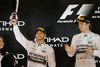 Mercedes’ verdensmester Lewis Hamilton med trofæet, mens holdkammerat Nico Rosberg ser til efter løbet i Abu Dhabi. Foto: Frank Augstein/AP