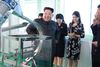 En altid veloplagt Kim Jong-un på besøg på en kosmetikfabrik i Nordkoreas hovedstad, Pyongyang, i søndags. Kvinden i den blomstrende kjole er hans hustru, Ri Sol-ju, der stadigt oftere viser sig offentligt. Foto: AP