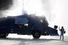En tilhænger af oppositionen i Hviderusland står ved siden af en af politiets vandkanoner under demonstrationerne i Minsk. Foto: Reuters