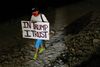 A person holds a sign as supporters of former U.S. President Donald Trump stand outside his Mar-a-Lago home after Trump said that FBI agents raided it, in Palm Beach, Florida, U.S., August 8, 2022. REUTERS/Marco Bello
