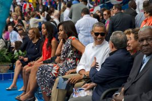 USA's præsident Barack Obama - i selskab med sin familie - ses her i samtale med Cubas præsident Raul Castro ved en baseball kamp under besøget i Cuba.