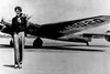 Den 39-årige Amelia Earhart ved siden af sit Lockheed Electra 10E-fly ved begyndelsen af forsøget på at flyve kloden rundt i 1937. Første etape gik fra Oakland i Californien til Honolulu på Hawaii. Hendes senere forsvinden udløste talrige teorier om, at den berømte pilot ikke var død, men måske havde arrangeret et forsvindingsnummer. Arkivfoto: AP