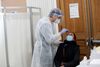 En sundhedsmedarbejder tester en indbygger i paris for coronavirus. Hospitalerne i den franske hovedstad kan i den kommende tid blive voldsomt belastet af folk smittet med virussen. Foto: Benoit Tessier/Reuters