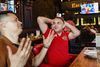 På en sportsbar i det centrale Rostov sidder tre venner og følger træningskampen mellem VM-værterne Rusland og Tyrkiet. Aleksej Ukolov (th) og Mikhail Novotarsky kan næsten ikke tro deres øjne, da Rusland scorer til 1-0 mod Tyrkiet. Foto: Gregers Tycho