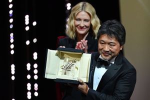 Den japanske instruktør Hirokazu Kore-Eda poserer med beviset for, at han har vundet Guldpalmen ved årets filmfestival i Cannes. I baggrunden står skuespillerinden Cate Blanchett, der var med i juryen.
Foto: ALBERTO PIZZOLI
