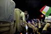 Tidligt onsdag krydsede 150 oprørere fra Syriens Frie Hær via Tyrkiet grænsen til Syrien for at støtte kurderne i Kobani i kampen mod Islamisk Stat. Her er det en kurdisk Peshmerga-kriger, der hilser på tilhængere undervejs mod Kobani.
