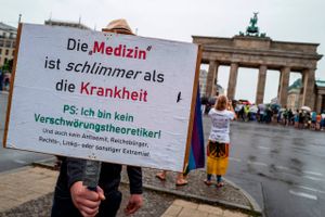 "Medicinen er værre end sygdommen", står der på skiltet, som blev vist frem ved den demonstration mod myndighedernes coronarestriktioner, som foregik i Berlin i søndags og som gentages i Stuttgart i denne weekend. Foto: John McDougall/AFP