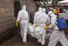 Sundhedsarbejdere fjerner liget af en kvinde, der er mistænkt for at være død af ebola i et kvarter i Liberias hovedstad, Monrovia. Foto: Abbas Dulleh/AP