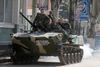 Et pansret køretøj med prorussiske militsfolk på vej gennem Slavjansk fredag. Det er uvist, om køretøjet er et af dem, de prorussiske militsfolk har erobret fra den ukrainske hær.