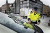John Hansen placerer en p-afgift i forruden på en bil i Aarhus, der holder ulovlig parkeret. Foto: Tanja Carstens Lund