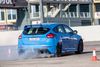 Blå røg fra baghjulene på en blå bil. Den nye Über-GTI fra Ford, Focus RS, har træk på alle fire hjul. Og så kan den pludseligt opføre sig sådan her – donuts for fuld pedal.
