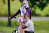 En mor og hendes søn kører på cykel uden for et flygtningehjem i Frankfurt. Foto: Michael Probst/AP.