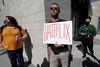 Dave Briggs holds a placard as he attends a rally in support of the Netflix transgender employee walkout "Stand Up in Solidarity" to protest the streaming of comedian Dave Chappelle?s new comedy special, in Los Angeles, California, U.S. October 20 2021. REUTERS/Mario Anzuoni