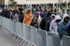 Emigranter står i kø til udlevering af mad i Calais i Frankrig.