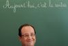 Hollande kom måske til at smile lidt for bredt under besøget på en skole. Dette foto er taget af AP's fotograf, mens AFP tilbagekaldte de fotos, bureauet først havde sendt ud.