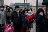 In this picture taken on January 27, 2020 people wearing protective masks to help stop the spread of a deadly virus which began in Wuhan, queue to take a taxi at the Beijing railway station. - The deadly new coronavirus that has broken out in China, 2019-nCoV, will afflict a minimum of tens of thousands of people and will last at least several months, researchers estimate based on the first available data. (Photo by NICOLAS ASFOURI / AFP)