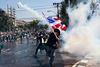 En deltager i gårsdagens demonstrationer mod den thailandske regering kaster en tåregasgranat tilbage mod politiet. Foto: Wason Wanichakorn/AP